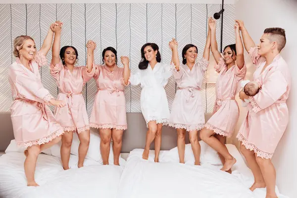Bridal party in blush robes celebrating before the ceremony