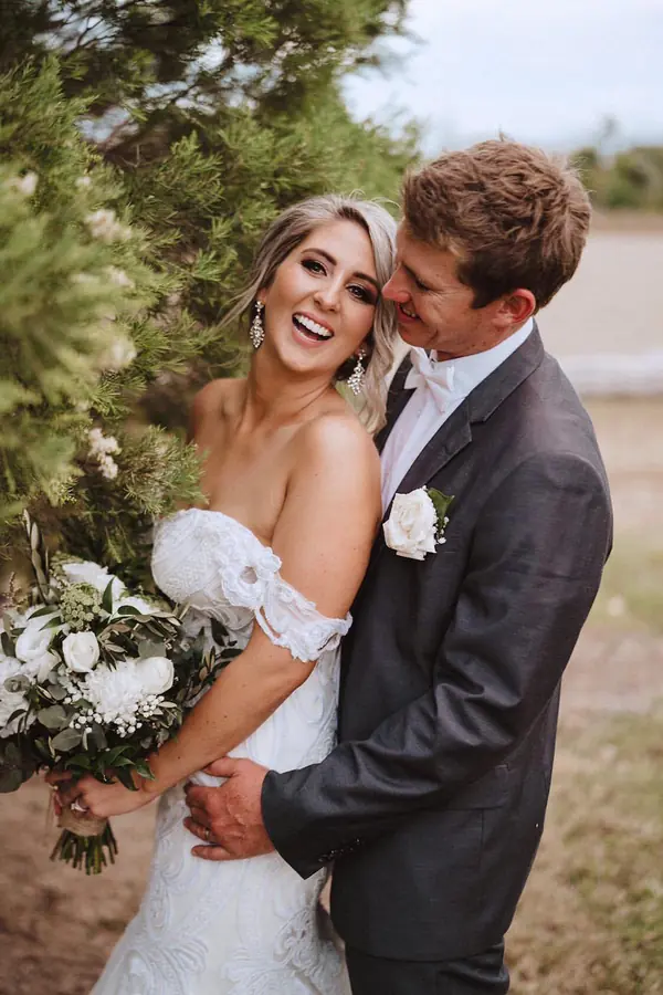 Bride and groom laughing together in a garden