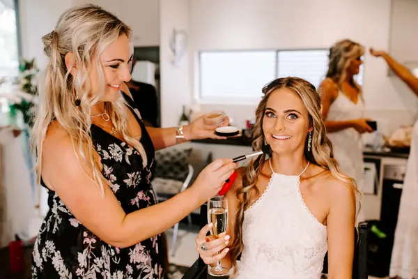 Carly finishing a blonde bride's makeup