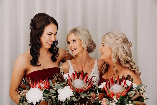 Bride with bridesmaids holding protea bouquets