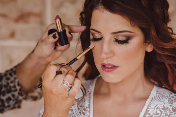 Eyeshadow being applied to a dark-haired bride