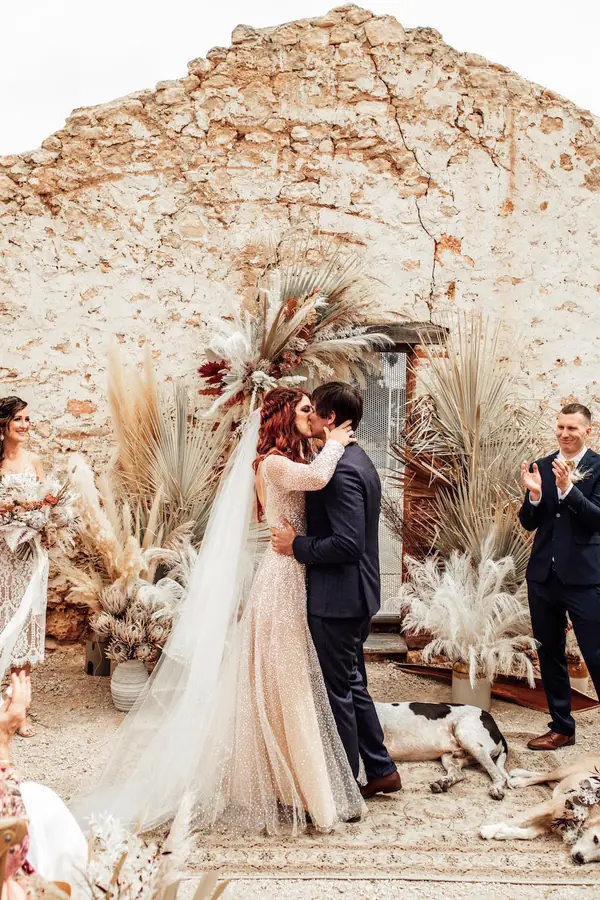 Couple at a boho ceremony under stone ruins