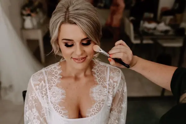 Close-up of glowing bridal makeup and lace robe
