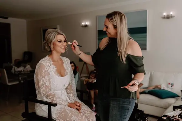 Makeup being applied in a bright bridal suite