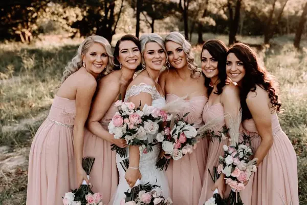 Bridesmaids in pink dresses laughing together