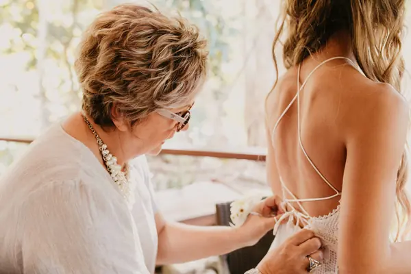 Bride's gown being buttoned up the back
