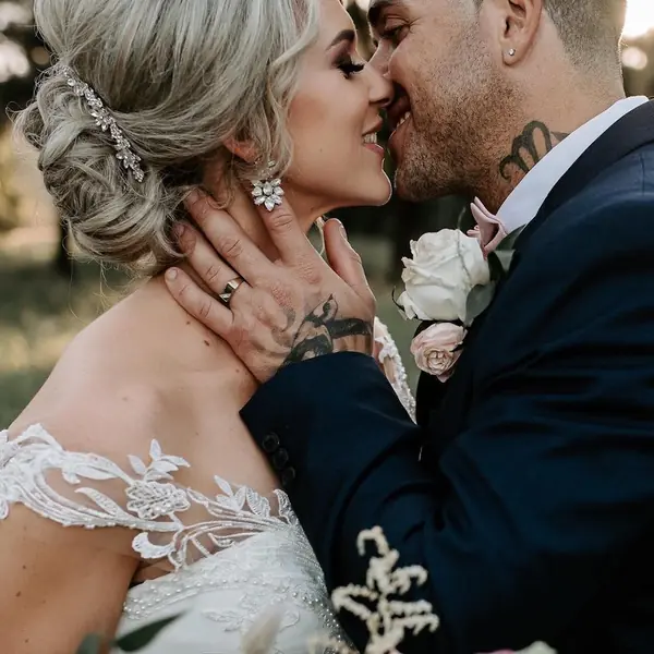 Groom kissing the bride, her hair in a soft updo