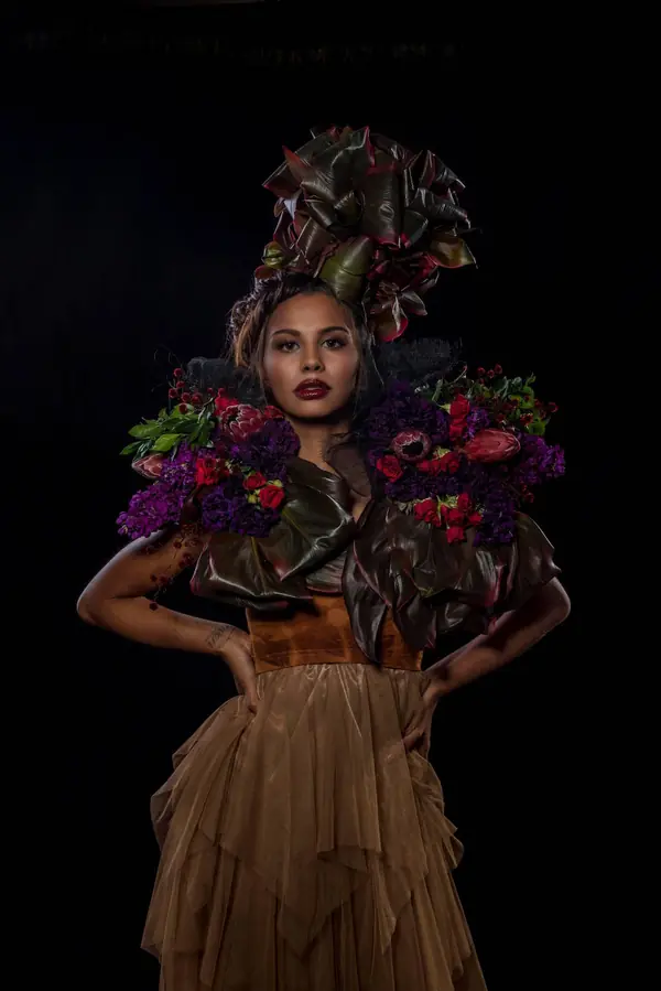 Model in a dramatic floral headpiece with a bold lip