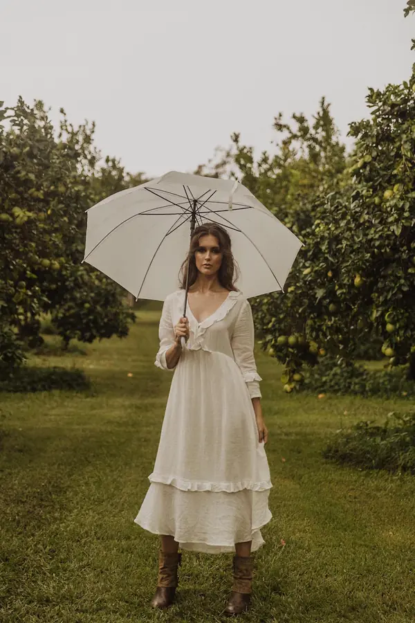 Model in a white dress holding a parasol