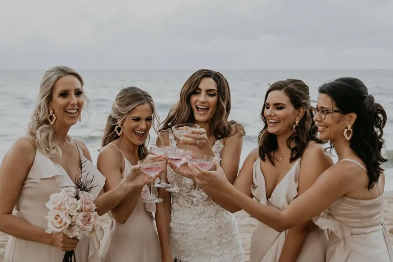 Bridesmaids laughing together on the beach