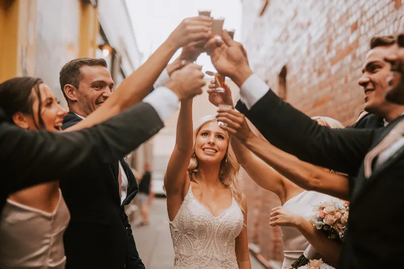 Bride and groom raising a toast with guests
