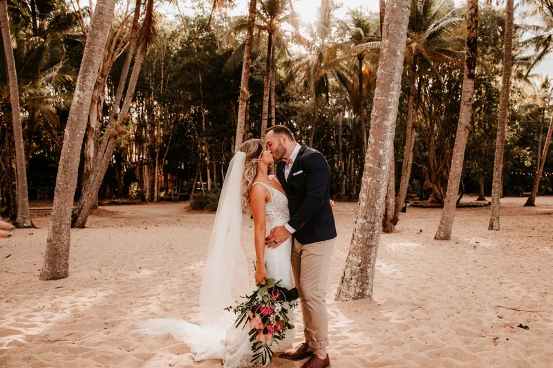 Newlyweds among the palms on a Far North Queensland beach